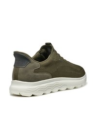 Zapatillas de color verde oliva con parte superior de ante y malla, suela blanca acolchada y tacón redondeado. Presenta un acento de logo negro en la parte trasera.