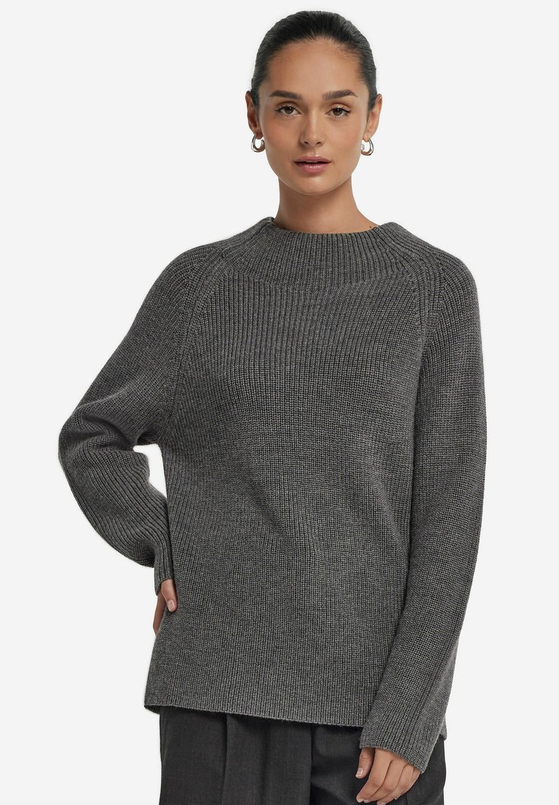 Grauer Strickpullover mit geripptem Muster, lockerer Passform und hohem Kragen. Mit überschnittenen Schultern und langen Ärmeln.