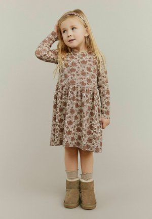 Brown floral-patterned long-sleeve dress with a gathered skirt. Paired with tan boots and cream ankle socks. Simple headband accessory.