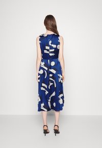 Blue sleeveless dress featuring abstract white and black patterns, knee-length design with a fitted waist and flowing skirt.