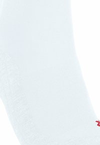 Biała skarpetka z prążkowaną teksturą i małym czerwonym logo w pobliżu kostki, ustawiona pod kątem na białym tle.