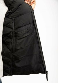 Czarna ocieplana kurtka z pikowaną podszewką, z kieszenią boczną, zapięciem na zamek oraz gładką fakturą materiału.