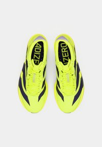 Jasnozielone buty sportowe z ciemnoniebieskimi paskami, charakteryzujące się lekką konstrukcją, teksturowaną cholewką i wyrazistym oznakowaniem na wkładkach.