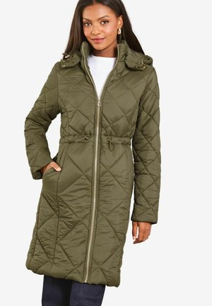 Manteau long en olive matelassé avec zip à l'avant, taille ajustable par cordon de serrage, et capuche. Comprend des poches latérales et un motif en losanges texturé.