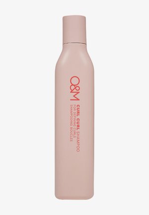 Curl shampoo bottle in matte light pink, elongated oval shape with a rounded top. Features red text for branding and product details.