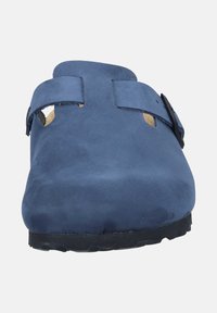 Sabot en suède bleu avec un dos ouvert, doté de deux brides ajustables et de trous de ventilation, monté sur une semelle extérieure en caoutchouc noir.