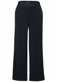 Granatowe spodnie z szerokimi nogawkami o miękkiej fakturze i elastycznym pasie z napisem "POZTYWNOŚĆ" w wytłaczanym wzorze.