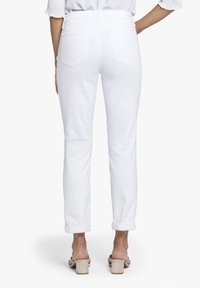 Witte denim jeans met rechte pijpen, omslagranden en twee achterzakken. Gladde textuur met minimale stikdetails.