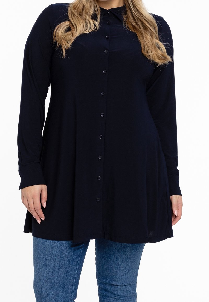 Blusa a maniche lunghe blu navy con colletto, realizzata in un tessuto liscio, caratterizzata da una vestibilità rilassata e orlo inferiore arrotondato.