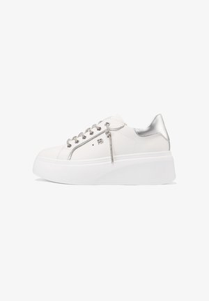 Sneaker bianco in pelle con dettaglio argentato sul tallone, suola piatta bianca e lacci argentati. Presenta un design minimale.