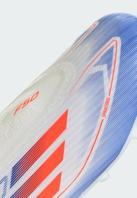 White soccer cleat featuring a gradient design with blue and orange accents. Textured surface and "F50" branding visible. Lightweight construction.