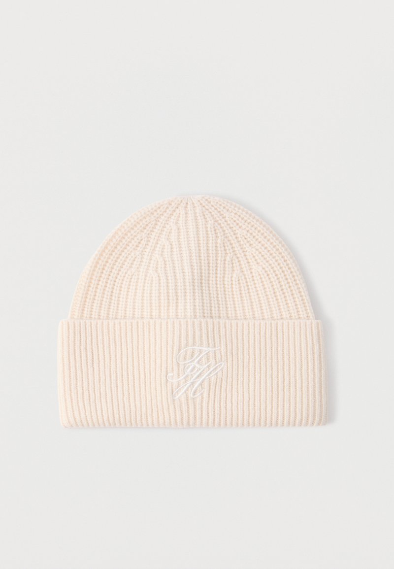 Cream-colored ribbed knit beanie with folded cuff and white embroidered initials "TH" on front center.