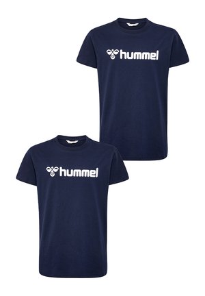 Navyblauwe T-shirts met een wit logo, gecombineerd met grijze joggingsbroeken. Modellen dragen witte schoenen met zwarte accenten. Casual, comfortabele sportkleding.