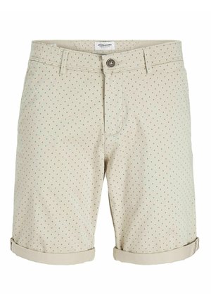 Bezs színű rövidnadrág zöld és kék pöttyös mintával. Gombos záródás, elülső zsebek és feltekert szegély díszítéssel. Pamut keverékből készült.