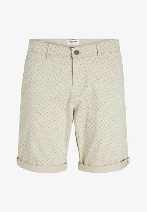 Bezs színű rövidnadrág zöld és kék pöttyös mintával. Gombos záródás, elülső zsebek és feltekert szegély díszítéssel. Pamut keverékből készült.