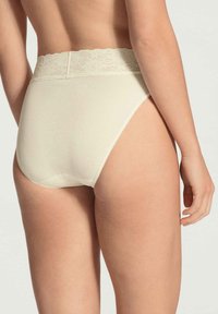 Hochgeschnittene cremefarbene Unterwäsche mit einem Spitzenbund, glattem Stoff und einem nahtlosen Rückendesign.