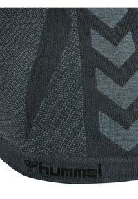 Calcetín deportivo de punto en gris oscuro con patrones texturizados y acentos en chevron gris claro. Presenta un logo negro en el puño.