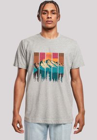 Grijze t-shirt met korte mouwen met een grafisch ontwerp van bergen en bomen in levendige kleuren, met een gestructureerd, gelaagd ontwerp.
