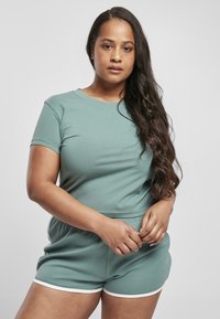 Lysegrønn bomullstopp med korte ermer og matchende shorts, med løs passform, elastisk midje og hvite detaljer på shortsen.