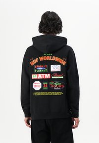 Black hooded sweatshirt featuring colorful graphics on the back, including logos and text for "HUF WORLDWIDE" and other signage elements.