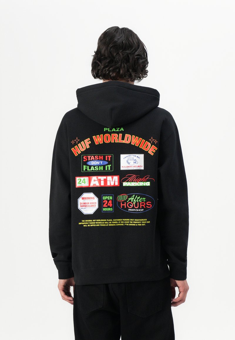 Black hooded sweatshirt featuring colorful graphics on the back, including logos and text for "HUF WORLDWIDE" and other signage elements.