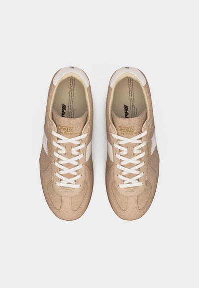 Bež antilop superge z belimi vezalkami in stranskimi črtami, blagovna znamka Polo Ralph Lauren na jezičku in strani, pogled od zgoraj.