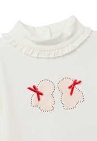 Collo alto bianco con colletto arricciato. Presenta applicazioni di coniglietti rosa con fiocchetti rossi e borchie decorative che delineano le forme. Tessuto morbido.