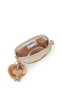Pieni beige vetoketjullinen pussi, jossa on Kipling-tunnus sis�ällä ja pörröinen apinakynäpidike kiinnitettynä vetoketjun vetimeen.