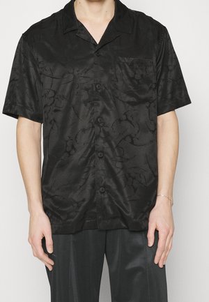 Schwarzes Kurzarmhemd aus glattem Material, mit einem dezenten Blumenmuster, einem klassischen Kragen und einer Brusttasche mit Knopfverschluss.