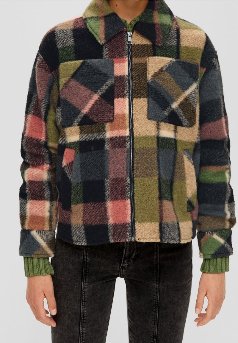 Chaqueta de forro polar con un patrón de cuadros multicolor en rosa, verde, azul marino y beige. Incluye cierre con cremallera en la parte delantera y dos bolsillos en el pecho.