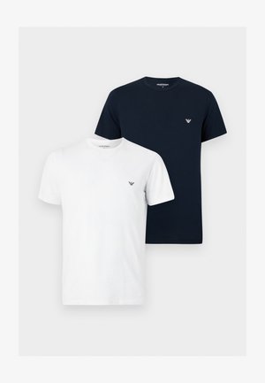 Kaksi yksiväristä pyöreäkaulaista t-paitaa, yksi valkoinen ja yksi musta, molemmissa pieni logo vasemmalla rinnassa.