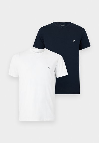 Δύο μονόχρωμα T-shirts με στρογγυλή λαιμόκοψη, ένα λευκό και ένα μαύρο, το καθένα με μικρό λογότυπο στο αριστερό στήθος.