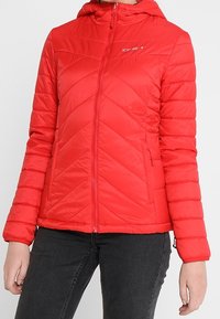 Červená zateplená bunda s kapucí, která má vzor cik-cak, přední zip a dvě boční kapsy. Materiál vypadá hladce a lehce.