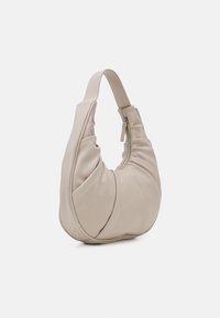 Beżowa torba na ramię o miękkim, teksturowanym wzorze. Posiada zaokrąglony kształt, falbaniaste detale oraz zamek błyskawiczny z krótkim uchwytem.