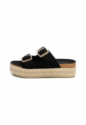 Sandal plataforma negra con doble hebilla, textura trenzada y una media suela estilo yute con un acento de corcho. Suela plana de goma para tracción.