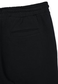 Jogging neri con vita elastica e una piccola tasca sul retro. Il tessuto sembra morbido con una texture liscia. Design semplice.