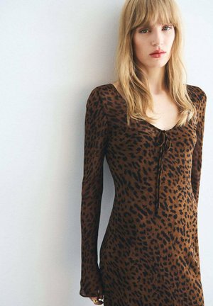 Leopard print dress in brown and black, long sleeves, fitted silhouette, scoop neckline with tie detail at the front, soft texture.
