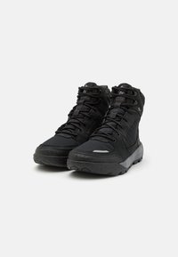 Botas de senderismo negras con materiales de malla y ante, cuentan con un diseño de cordones, un cuello acolchado y una suela de goma texturizada para un mejor agarre.