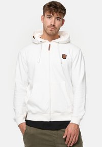 Weiße Kapuzenjacke mit Reißverschluss aus weichem Stoff, mit einstellbarem Kapuzenzug, Fronttaschen und einem kleinen Logo-Patch auf der linken Brust.