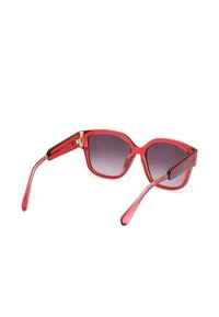 Occhiali da sole oversize rossi con lenti sfumate. Presentano una montatura in plastica lucida e slanciata, con aste sottili e dettagli in hardware dorato.