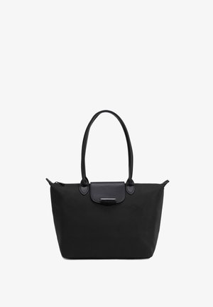 Sac cabas noir avec longues poignées, rabat avant avec petit logo métallique et fermeture éclair sur le dessus.