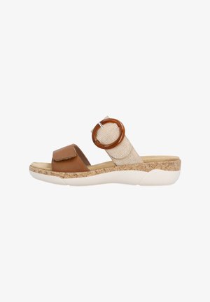 Brown and beige open-toe sandal with cushioned sole, wide front strap, fabric ankle strap, and large round buckle detail.