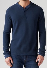 Marineblaues Langarm-Henley-Shirt aus Rippstrickstoff, mit einer Zwei-Knopf-Leiste, rundem Ausschnitt und enganliegenden Bündchen.