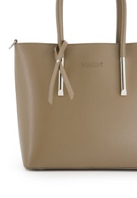 Beige syntetická taška přes rameno s dvěma dlouhými uchy; zahrnuje stříbrné kování a křížové detail na přední straně. Tisknuté logo "VENEZIA".