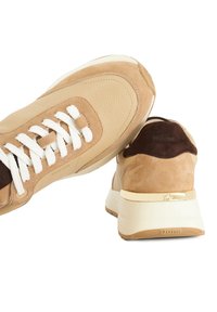 Baskets en cuir et daim beige avec des lacets blancs, bout arrondi et talon rehaussé de doré. Fini texturé et semelle rembourrée.