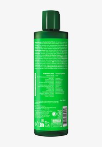 Grüne Kunststoffflasche mit einem Klappdeckel. Auf der Rückseite sind weiße Schriftzüge mit Zutaten und Produktdetails vorhanden. Auf der Vorderseite ist kein sichtbares Branding.