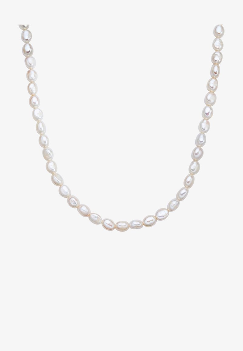 Valge magevee pärlite kaelakee ovaalsete helmedega, millest igaüks peegeldab valgust. Sile tekstuur kergete pindade läike erinevustega.