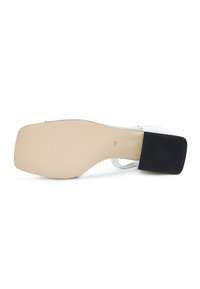 Sandal blanc avec une semelle à bout carré, un petit talon bloc noir, et la taille 39 marquée sur la semelle beige, présenté à plat sur un fond blanc.