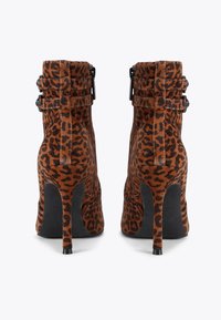 Leopard print ankle boots featuring suede material, high stiletto heels, and dual ankle straps for added detail.