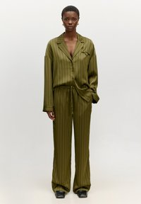 Olijfgroene satijnen pyjamセット met verticale strepen; langemouwenhemd met een notch-kraag, broek met trekkoord en een wijd ontwerp.